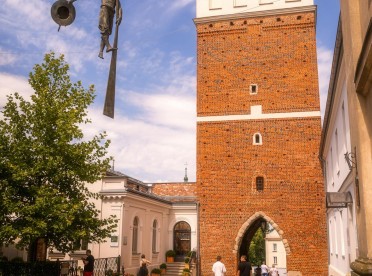 Brama Opatowska w Sandomierzu z balansującą rzeźbą flisaka