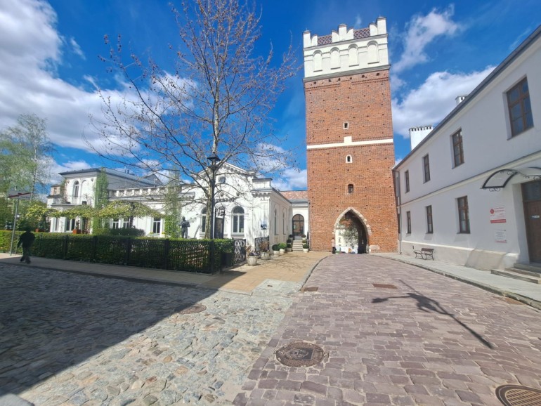 Brama Opatowska w Sandomierzu z balansującą rzeźbą flisaka
