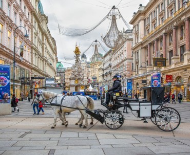 Świątecznie ozdobiona ulica Wiednia z malowniczą karocą zaprzężoną w konie