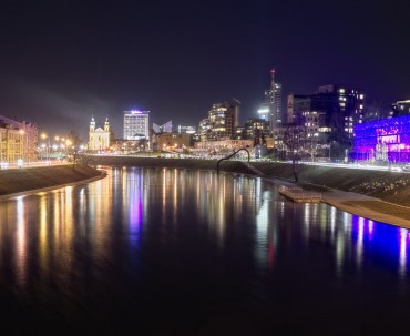Nocny widok na rzekę Wilię i podświetloną panoramę biznesowej części Wilna z Kościołem św. Rafała Archanioła w tle